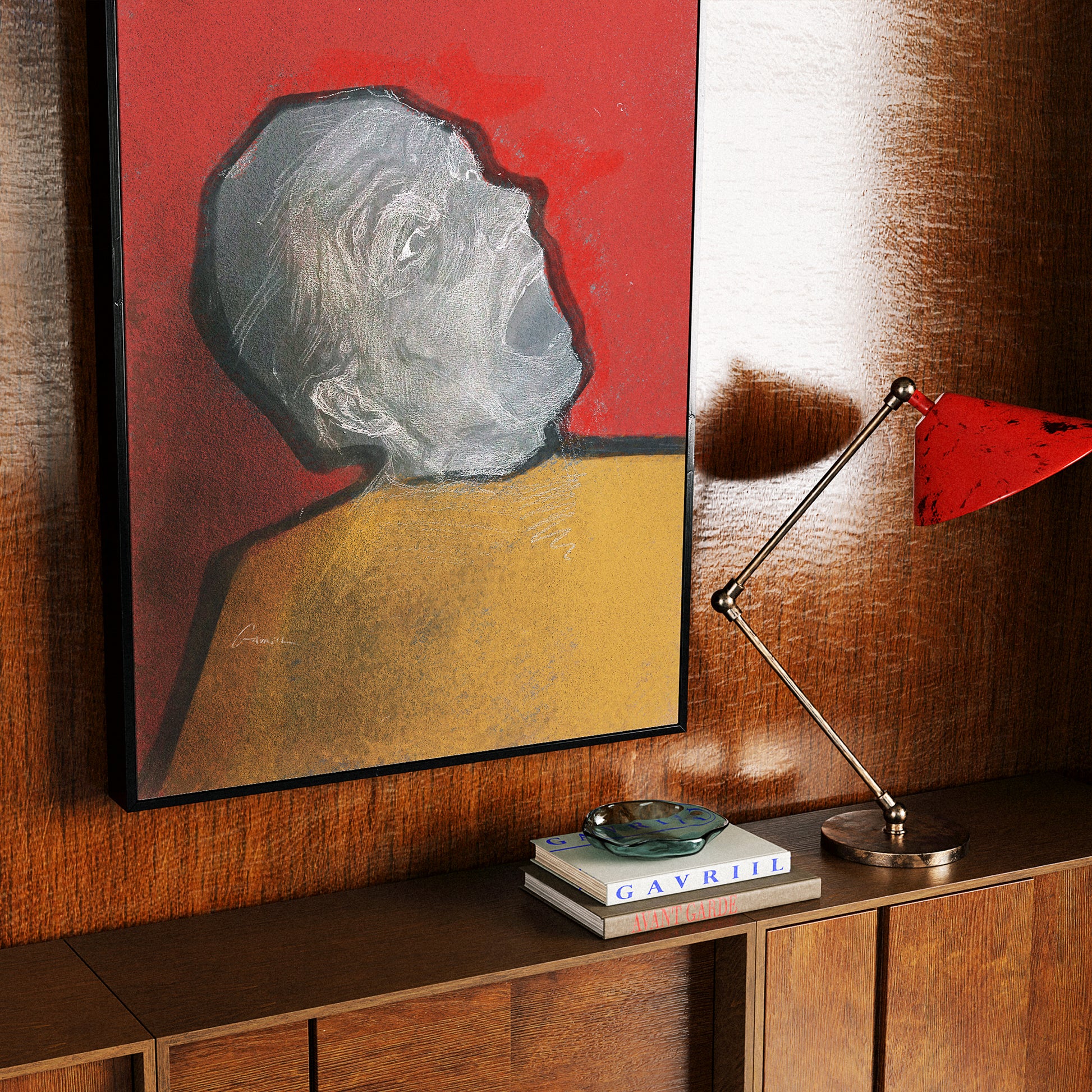 A framed portrait art print of a screaming man in profile against a red background, displayed on a wooden wall above a cabinet with books and a red lamp nearby.
