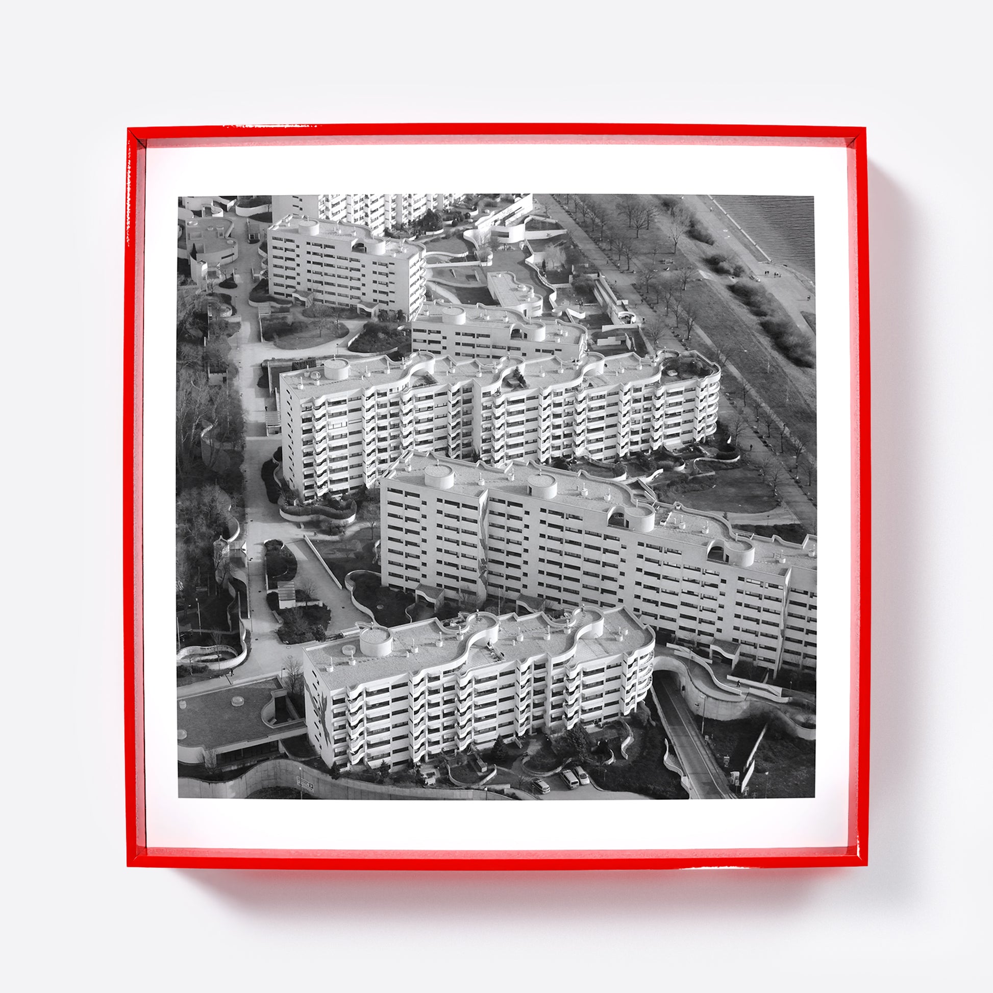 Art print depicting an aerial view of a residential area with apartment buildings in a red frame.