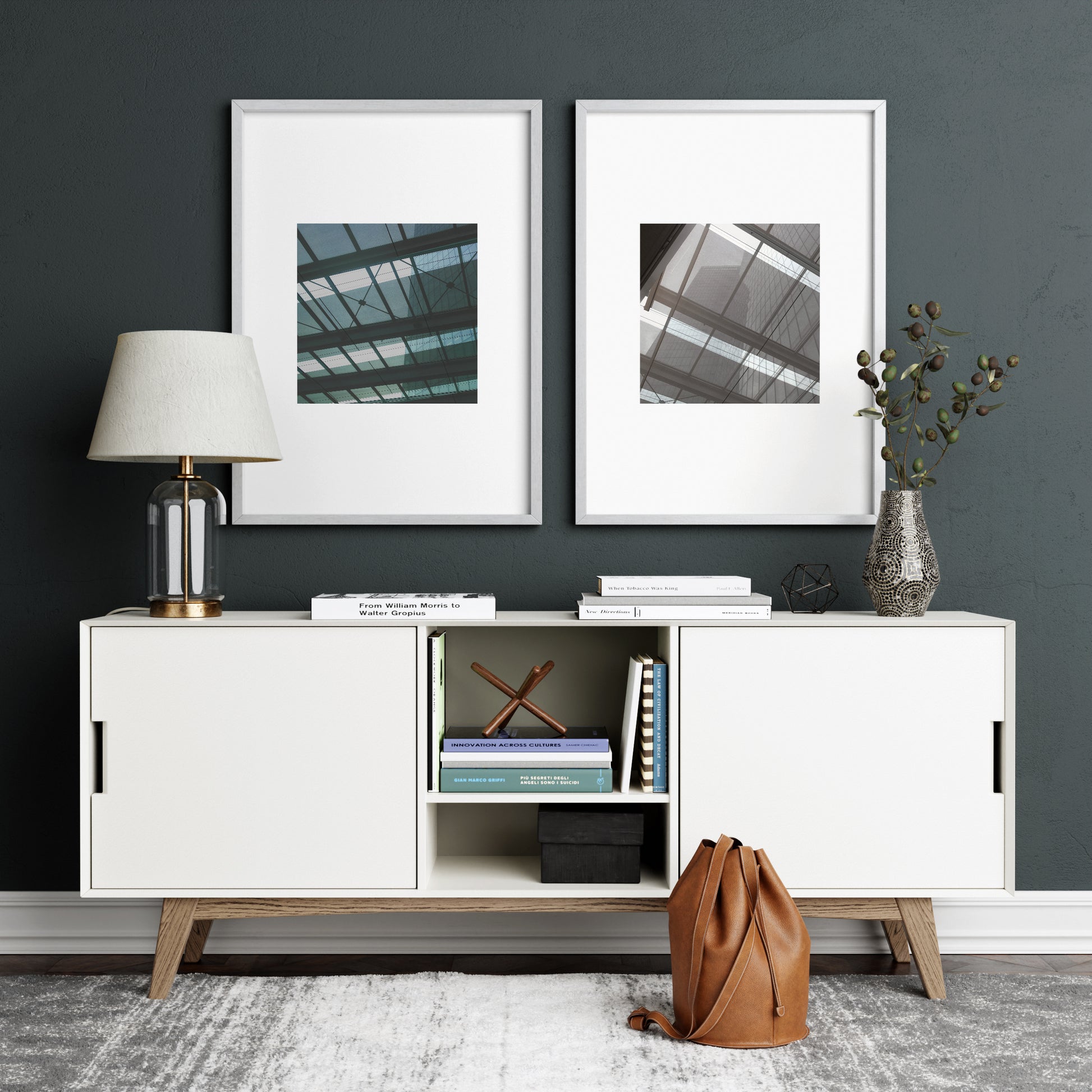 Two modern architectural urban photography art prints on a dark green wall.
