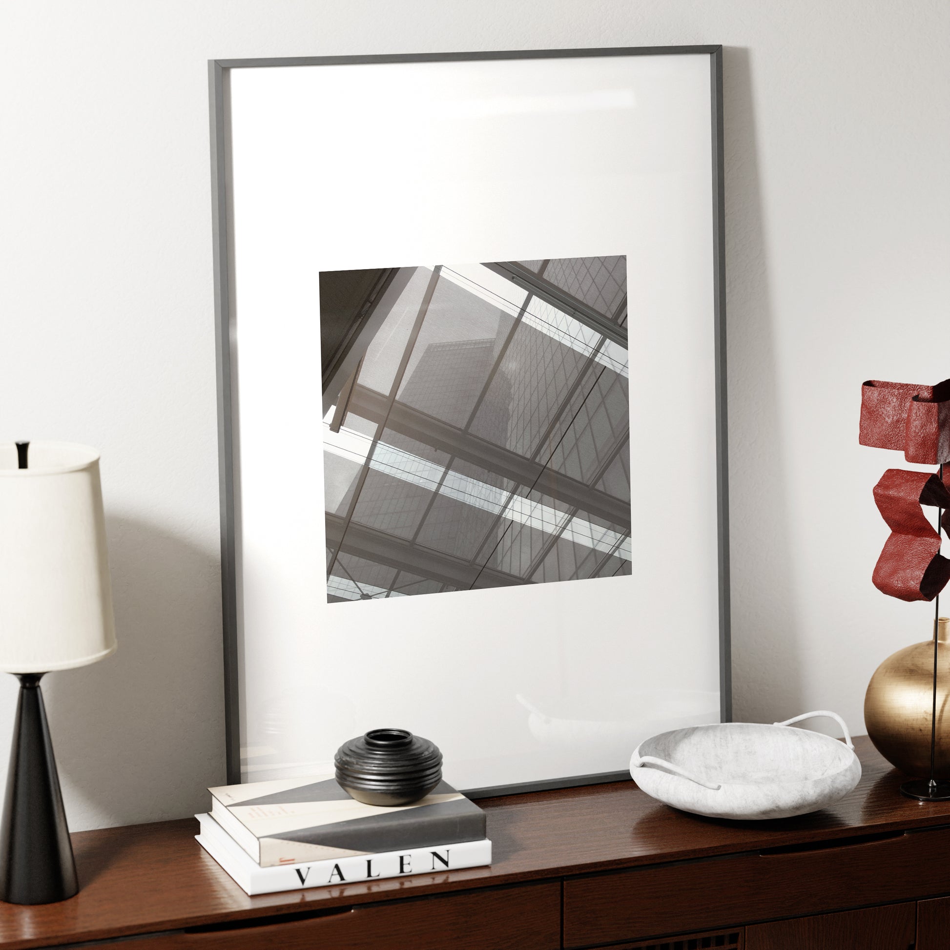 Monochrome modern architectural photography art print on a dark wood sideboard.